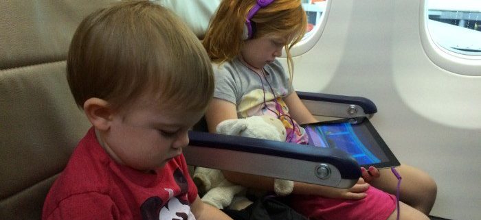 two small children on page watching ipads